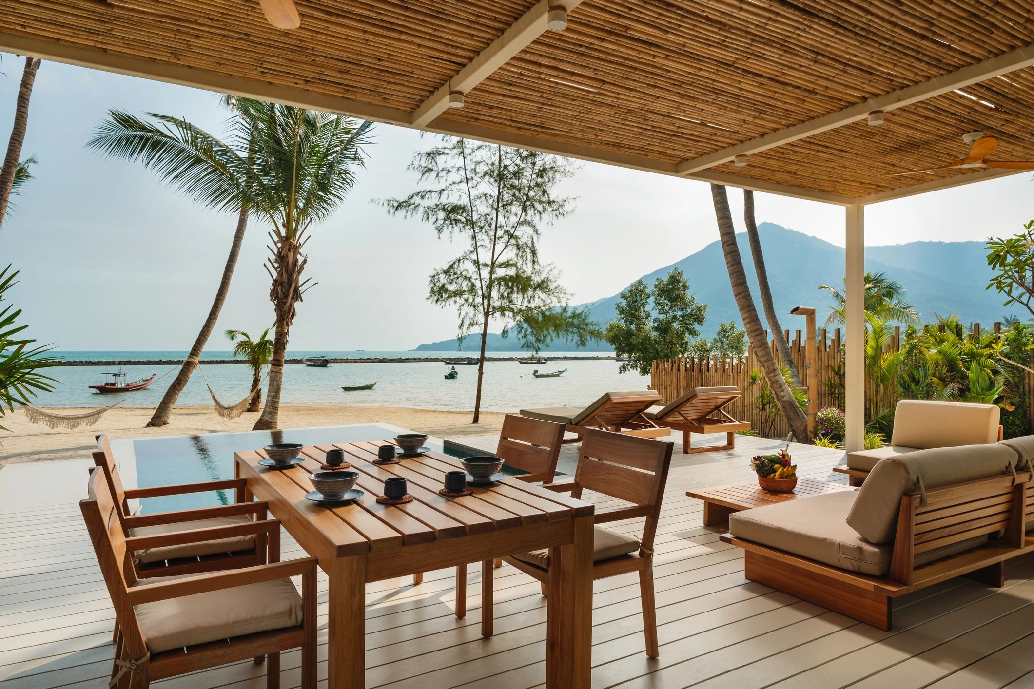 Outdoor dining area overlooking a tropical beachfront villa